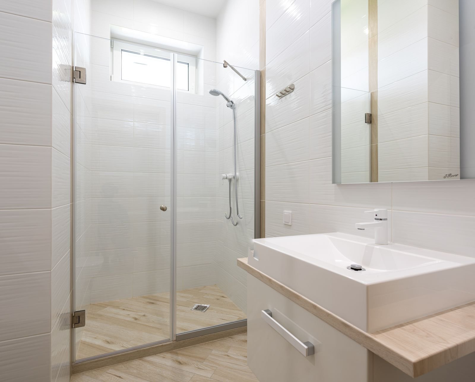 Salle de bain blanche avec douche vitrée propre
